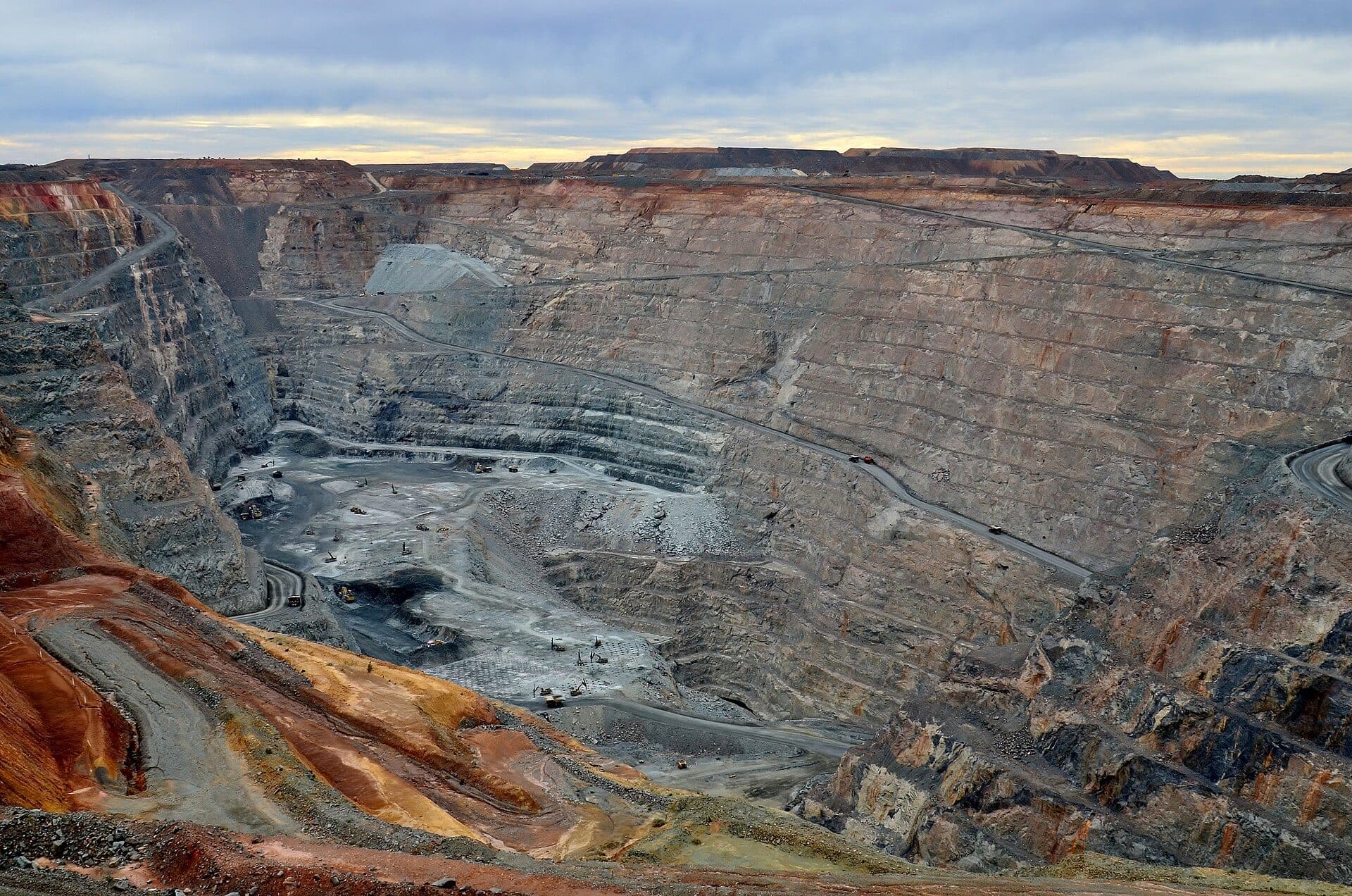 Wide view across the Super Pit gold mine showing benches, haul roads and equipment on the pit floor